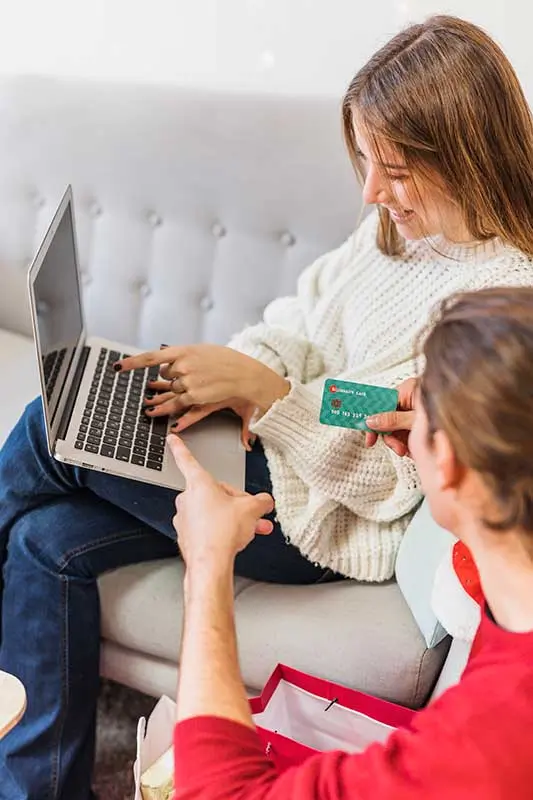 Κατασκευή ιστοσελίδων και eshop - άντρας και γυναίκα ψωνίζουν απο το καναπέ τους απο eshop