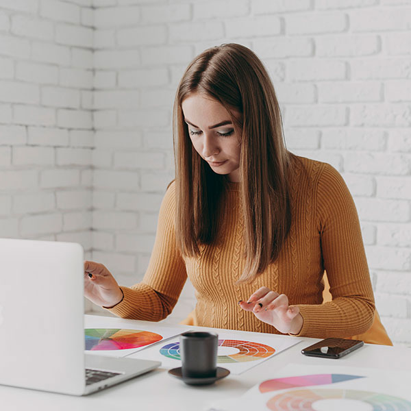 Γυναίκα εργάζεται σε υπολογιστή, αναλαμβάνοντας την ανακατασκευή ιστοσελίδας για τη βελτίωση της εμφάνισης και λειτουργικότητας της επιχείρησης
